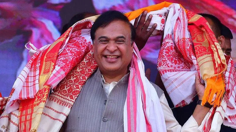 Himanta Biswa Sarma Begins Second Term as Assam Chief Minister Election Victory in Assam Himanta Biswa Sarma has been sworn in again as chief minister of Assam after a strong win for the ruling party. Bharatiya Janata Party won 82 out of 126 seats in the state assembly election. Its partners secured 20 more seats, giving the alliance a clear majority. The party has stayed in power since 2016 and continues to strengthen its position in the region. Political Journey and Rise Sarma represents the Jalukbari constituency near Guwahati, Assam’s largest city. He has held this seat since 2001. He began his political career in the Congress party and worked as a minister under former chief minister Tarun Gogoi. Later, he switched to the Bharatiya Janata Party in 2015. His move brought several supporters with him and weakened the Congress party in Assam. His shift also helped the BJP expand quickly in the region. Role in BJP Expansion in Northeast India Sarma played a major role in building the BJP’s presence across northeast India. The party once had limited support in Assam, with a low vote share for many years. Over time, its support grew significantly and now stands much higher than before. He worked closely with local groups and helped the party form alliances in nearby states. His organizational skills made him an important figure in the party’s regional strategy. Governance and Welfare Programs During his leadership, the state government focused on infrastructure development such as roads and bridges. One of the key welfare schemes is Orunodoi, which provides financial support to women from low income families. Supporters say this program has helped many households across Assam. His administration has also focused on public services and development projects. Criticism and Political Debate Sarma’s leadership has also faced criticism. Opposition parties and rights groups accuse the government of targeting minority communities, especially Bengali speaking Muslims. Issues such as migration, identity, and citizenship remain sensitive in Assam politics. Some policies linked to religious schools and child marriage have sparked public debate. A recent AI generated video shared by the state party unit also triggered controversy before being removed.