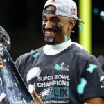 Eagles Set for London Game in 2026 NFL Season as League Expands Globally Philadelphia Eagles Head to London The Philadelphia Eagles will return to London in the 2026 NFL season. They will be part of a major international schedule that includes a record number of games outside the United States. The Eagles last played in London in 2018. The game in London will take place at Tottenham Hotspur Stadium. It adds to the league plan of growing American football across global markets. NFL Expands to Nine International Games The NFL will stage nine regular season games across four continents in 2026. These matches will be played in seven different countries. The United Kingdom will host three games again. The league is also expanding into new regions. Australia and France will host NFL games for the first time. This marks a major step in the sport’s international growth. Jaguars and 49ers Lead Overseas Schedule The Jacksonville Jaguars and San Francisco 49ers will each play two games outside the United States. The Jaguars will also host games in London across two consecutive weeks. The 49ers will take part in international fixtures that include matches in Mexico. The Baltimore Ravens and Dallas Cowboys will also play in Brazil in the league’s first game in Rio de Janeiro. London Games Schedule London will open its NFL run on 4 October. The Washington Commanders will face the Indianapolis Colts at Tottenham Hotspur Stadium. The Jaguars will then host the Eagles the following week at the same venue. After that, they will meet the Houston Texans at Wembley Stadium. This will be a divisional game, which is rare outside the United States. Games Across Europe and Australia The NFL will also stage games in other major cities. Paris will host its first NFL game at Stade de France, where the New Orleans Saints will meet the Pittsburgh Steelers. Real Madrid’s stadium will host a game between the Cincinnati Bengals and Atlanta Falcons. Munich will see the New England Patriots face the Detroit Lions. The opening international game of the season will be played in Australia. The Los Angeles Rams will face the San Francisco 49ers at the Melbourne Cricket Ground. League Reaction and Expansion Goals NFL UK and Ireland leadership said the 2026 schedule features major stadiums and strong matchups. They highlighted the Eagles as a strong and competitive team returning to London. They also noted that divisional games played outside the United States are still uncommon. The Jaguars hosting the Texans in London was described as a key moment for international growth.