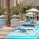 German Tourist Wins Refund After Sun Lounger Struggle in Greece Family Awarded Compensation Over Poolside Sunbed Problem A German tourist has received compensation after struggling to find a sun lounger during a family holiday in Greece. The court ruled that the holiday experience failed to meet reasonable expectations because guests regularly reserved loungers with towels for long periods. The tourist travelled to the Greek island of Kos with his wife and two children in 2024. According to court reports, the family woke up at 6:00 AM every day to search for available loungers near the pool. Despite their early efforts, they still could not secure seats because many guests had already reserved them using towels. The man explained that he spent nearly 20 minutes each morning looking for empty loungers. In some cases, his children had to sit or lie on the ground because no poolside space remained available. The family paid more than €7,000 for the package holiday. After returning home, the tourist filed a complaint against the tour operator. He argued that the company failed to properly manage the hotel’s sunbed policy and did not stop guests from reserving loungers for hours without using them. At first, the travel company offered the family a partial refund of €350. However, a district court in Hanover later ruled that the compensation was too low. Judges decided the family deserved a larger refund of €986.70 because the holiday conditions were “defective.” The court also stated that although the tour operator did not directly manage the hotel, it still had a responsibility to ensure guests had fair access to basic facilities such as poolside loungers. The issue of “sunbed wars” has become increasingly common at popular tourist resorts across Europe. Many holidaymakers reserve loungers early in the morning by placing towels on them before leaving for hours. Last year, several viral videos from Tenerife showed tourists rushing to claim poolside spots at sunrise. Some visitors were even seen sleeping beside pools to secure better locations. Travel companies and resorts are now trying different ways to solve the problem. Some hotels have introduced time restrictions on towel reservations, while others remove unattended belongings after a certain period. Meanwhile, some regions in Spain have warned tourists that they could face fines of up to €250 for reserving sun loungers and leaving them unused for long periods. Why Sun Lounger Disputes Are Increasing Tourism experts say overcrowded resorts and limited poolside seating continue to create frustration among travellers during peak holiday seasons. Families often expect relaxing pool access as part of their vacation package, especially when paying premium prices for resort stays. As more travellers share complaints online, hotels and tour operators may face increasing pressure to improve resort management and enforce fair sunbed rules.