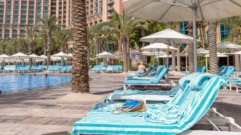German Tourist Wins Refund After Sun Lounger Struggle in Greece Family Awarded Compensation Over Poolside Sunbed Problem A German tourist has received compensation after struggling to find a sun lounger during a family holiday in Greece. The court ruled that the holiday experience failed to meet reasonable expectations because guests regularly reserved loungers with towels for long periods. The tourist travelled to the Greek island of Kos with his wife and two children in 2024. According to court reports, the family woke up at 6:00 AM every day to search for available loungers near the pool. Despite their early efforts, they still could not secure seats because many guests had already reserved them using towels. The man explained that he spent nearly 20 minutes each morning looking for empty loungers. In some cases, his children had to sit or lie on the ground because no poolside space remained available. The family paid more than €7,000 for the package holiday. After returning home, the tourist filed a complaint against the tour operator. He argued that the company failed to properly manage the hotel’s sunbed policy and did not stop guests from reserving loungers for hours without using them. At first, the travel company offered the family a partial refund of €350. However, a district court in Hanover later ruled that the compensation was too low. Judges decided the family deserved a larger refund of €986.70 because the holiday conditions were “defective.” The court also stated that although the tour operator did not directly manage the hotel, it still had a responsibility to ensure guests had fair access to basic facilities such as poolside loungers. The issue of “sunbed wars” has become increasingly common at popular tourist resorts across Europe. Many holidaymakers reserve loungers early in the morning by placing towels on them before leaving for hours. Last year, several viral videos from Tenerife showed tourists rushing to claim poolside spots at sunrise. Some visitors were even seen sleeping beside pools to secure better locations. Travel companies and resorts are now trying different ways to solve the problem. Some hotels have introduced time restrictions on towel reservations, while others remove unattended belongings after a certain period. Meanwhile, some regions in Spain have warned tourists that they could face fines of up to €250 for reserving sun loungers and leaving them unused for long periods. Why Sun Lounger Disputes Are Increasing Tourism experts say overcrowded resorts and limited poolside seating continue to create frustration among travellers during peak holiday seasons. Families often expect relaxing pool access as part of their vacation package, especially when paying premium prices for resort stays. As more travellers share complaints online, hotels and tour operators may face increasing pressure to improve resort management and enforce fair sunbed rules.