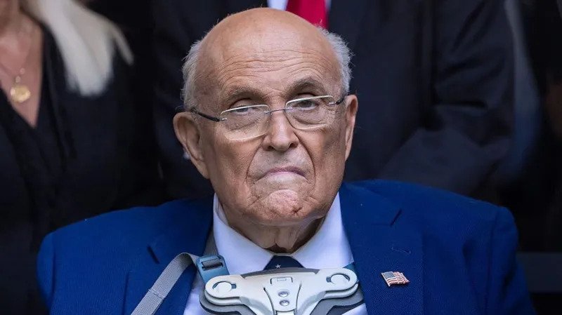 Rudy Giuliani Health Update: Breathing on His Own After Pneumonia Hospital Condition and Current Progress Former New York City mayor Rudy Giuliani is currently in hospital recovering from pneumonia. His spokesperson confirmed that he is now breathing without mechanical ventilation. He still remains under close medical supervision in critical but stable condition. Doctors had earlier placed him on ventilator support when his condition worsened. Medical teams removed the support after his breathing improved. His family and primary doctor are staying close during his treatment. Underlying Health Complications Giuliani has long been affected by respiratory issues linked to lung damage diagnosed after the September 11 attacks. His spokesperson said these existing conditions made it harder for his body to fight pneumonia. The illness developed quickly and severely impacted his breathing. Medical staff had to act fast to stabilize his oxygen levels before he improved. Connection to 9/11 Health Impact Giuliani was mayor of New York City during the September 11 attacks. He was widely recognized for his leadership during the crisis and earned the nickname America Mayor. Exposure to toxic dust and smoke after the attacks led to long term health problems for many first responders and city workers. Researchers have reported that these illnesses have claimed more lives over time than the attacks themselves. Political Career and Public Life After leaving office in 2001, Giuliani pursued national politics. He later ran for president during the Republican nomination race but did not win. He later became a key supporter and legal advisor for Donald Trump during the 2016 presidential campaign. Legal and Financial Challenges Following the 2020 election, Giuliani faced legal trouble after promoting false claims about election fraud. A jury later ordered him to pay damages to election workers in a defamation case. He also faced disbarment, losing his ability to practice law, and later declared bankruptcy due to financial pressures. Latest Health Situation His spokesperson says he is now improving and responding to treatment. Doctors continue to monitor him closely while he remains hospitalized.