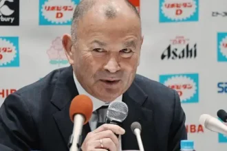 Eddie Jones Suspended as Japan Head Coach After Match Official Abuse Disciplinary Action Taken by JRFU Former England rugby head coach Eddie Jones has been fined and suspended from his role as Japan head coach after admitting to inappropriate comments directed at match officials during an under 23 tour in Australia last month. The Japanese Rugby Football Union confirmed the decision, saying the behaviour was serious enough to require strong disciplinary action under his contract. Jones has been removed from duty for six weeks and will miss Japan’s next four matches, including the opening Nations Championship fixture against Italy on 4 July. He will also be absent for two matches against a Hong Kong China Select team and a warm up game against the Maori All Blacks. The union has also reduced his salary as part of the punishment. Jones Issues Apology Jones accepted the sanction and expressed regret over his conduct. He said his remarks caused discomfort to local officials and others involved, and he apologised for the incident. The 66 year old acknowledged responsibility and said he understood the impact of his behaviour. Background and Recent Incidents Japan’s under 23 squad completed the tour with three wins from four matches, including a strong 38 to 21 victory over Randwick, a club closely linked to Jones’ coaching history. This is not the first time Jones has faced controversy since returning to Australia. After England’s series win over Australia in 2022, he was involved in tense exchanges with fans who accused him of disloyalty following his switch in coaching roles.