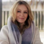 vKylie Minogue shares second cancer diagnosis in 2021 in new documentary Kylie Minogue has revealed that she faced a second cancer diagnosis in 2021, years after her first battle with breast cancer in 2005. She shared the update in her self titled Netflix documentary, where she spoke openly about the emotional weight of the experience and why she chose to keep it private at the time. Second diagnosis kept private Minogue explained that the diagnosis came in early 2021 following a routine medical checkup. Unlike her first cancer battle, she did not share the news publicly. She said she was not able to talk about it while going through treatment and recovery. She described that period as one where she felt emotionally drained and struggled with daily life. Even during major professional success, she was still dealing with the personal impact of illness. Life during recovery and public success While working through recovery, Minogue continued her music career. Her 2023 track Padam Padam became a major global hit and brought renewed attention to her work. She said that even during that success, she knew her health journey was still affecting her deeply. She explained that there were moments when she considered speaking about her diagnosis in interviews but could not bring herself to do it. She said she felt like she was not fully herself at times and preferred to focus on getting better quietly. Reflection on privacy and sharing her story Minogue said she does not feel an obligation to share every personal health detail publicly. However, she decided to include her story in the documentary to help others who may be going through similar experiences. She also highlighted the importance of regular health checkups and early detection. According to her, early diagnosis played a key role in her recovery both times. First cancer diagnosis in 2005 In 2005, Minogue was diagnosed with breast cancer during a routine check. She paused her Showgirl tour and stepped away from major performances to undergo chemotherapy and radiotherapy. The diagnosis was widely reported at the time, and she received strong public support during her treatment and recovery