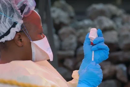 Ebola Outbreak in DR Congo Raises Concern Over Regional Spread Health authorities in the Democratic Republic of the Congo are closely monitoring a growing Ebola outbreak in the eastern part of the country. Early laboratory tests confirmed the virus in several samples collected from suspected patients. The Institut National de Recherche Biomédicale (INRB) in Kinshasa tested 20 samples and detected Ebola in 13 of them. Medical experts are now working to identify the exact strain of the virus. Officials reported 65 deaths linked to the outbreak. However, only four deaths have been confirmed through laboratory testing so far. Health teams continue to investigate other suspected cases in affected areas. Ebola Cases Confirmed in Eastern DR Congo The outbreak has mainly affected parts of Ituri province, including the provincial capital Bunia. Authorities also identified suspected infections in nearby communities. Laboratory teams are still checking samples from those areas. Health workers have increased monitoring efforts to prevent further transmission. Emergency teams are also tracing people who may have come into contact with infected patients. Health Officials Monitor Virus Strain Scientists are conducting more tests to determine the Ebola strain behind the outbreak. Identifying the strain will help medical teams improve response strategies and treatment planning. Health experts continue to study how quickly the virus spreads in the affected regions. Officials believe early detection remains critical for controlling the outbreak. Mining Towns Face Higher Risk Africa CDC warned that mining towns such as Mongwalu face a higher risk of transmission because of crowded conditions and frequent movement of workers. Urban areas like Bunia and Rwampara also remain vulnerable. Large populations and busy transport routes may increase the chances of the virus spreading further. Medical officials urged residents to follow safety guidelines issued by national health authorities. Communities have also received instructions on hygiene practices and reporting symptoms quickly. Regional Coordination Becomes Urgent Africa CDC Executive Director Jean Kaseya said cross border coordination is necessary because many people regularly travel between affected areas and neighboring countries. Health authorities from nearby nations are now discussing emergency response plans and surveillance measures. Officials want to strengthen border monitoring and improve communication between regional health agencies. The Congolese government has not officially declared a national outbreak yet. Authorities are expected to provide more updates as investigations continue and additional test results become available.
