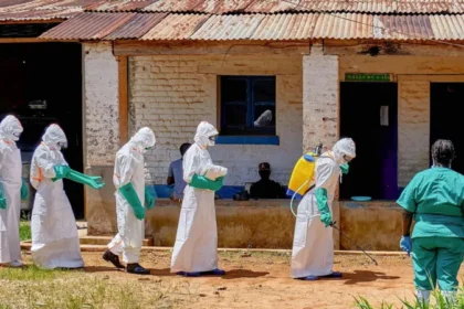 Police Fire Warning Shots as Crowds Gather at DR Congo Ebola Treatment Centre Tensions rose in eastern Democratic Republic of the Congo after police fired warning shots into the air to break up angry crowds outside an Ebola treatment centre in Mongwalu. Families reportedly tried to take back the bodies of relatives who had died from the deadly virus. Health officials said the unrest continued for several hours on Sunday. The treatment centre had already faced an overnight attack earlier in the weekend when unknown people set fire to an isolation tent inside the hospital compound. Families Demand Bodies of Victims According to hospital officials, several people gathered outside the medical facility demanding that authorities release the bodies of two Ebola victims to their families for burial. One of the victims was reportedly a respected Catholic religious leader known in the local community. Doctors warned that Ebola victims remain highly infectious after death. Traditional funeral practices and direct contact with bodies can quickly spread the virus to more people. Medical teams and Red Cross workers have been carrying out controlled burials under police protection to reduce the risk of further infections. Fear and Distrust Fuel Public Anger Many communities affected by the outbreak continue to distrust health authorities. Some residents question the real cause of deaths and remain skeptical about Ebola treatment measures. Earlier in the week, another violent incident took place in Rwampara, a town located southeast of Mongwalu. Protesters burned isolation tents after officials stopped them from removing the body of a suspected Ebola victim for a traditional burial ceremony. Health experts believe misinformation and fear are making it harder to control the outbreak. Ebola Cases Continue to Rise Officials say the current Ebola outbreak has now recorded more than 900 suspected cases and around 220 suspected deaths. The situation has raised concern across Central and East Africa. Red Cross officials also confirmed that three volunteers involved in handling dead bodies died from suspected Ebola infections. Their deaths highlight the dangers faced by frontline workers during the outbreak. Meanwhile, health ministers from Uganda, South Sudan, and the Africa Centres for Disease Control and Prevention recently agreed to strengthen cross border cooperation to help stop the virus from spreading into neighboring countries. Why Safe Burials Matter During Ebola Outbreaks Health experts say safe burials remain one of the most important steps in controlling Ebola outbreaks. The virus can survive in the bodies of victims after death, making funeral gatherings extremely risky. Authorities continue to urge families to cooperate with medical teams to protect communities and prevent more infections.