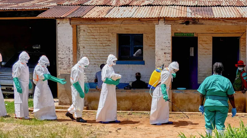 Police Fire Warning Shots as Crowds Gather at DR Congo Ebola Treatment Centre Tensions rose in eastern Democratic Republic of the Congo after police fired warning shots into the air to break up angry crowds outside an Ebola treatment centre in Mongwalu. Families reportedly tried to take back the bodies of relatives who had died from the deadly virus. Health officials said the unrest continued for several hours on Sunday. The treatment centre had already faced an overnight attack earlier in the weekend when unknown people set fire to an isolation tent inside the hospital compound. Families Demand Bodies of Victims According to hospital officials, several people gathered outside the medical facility demanding that authorities release the bodies of two Ebola victims to their families for burial. One of the victims was reportedly a respected Catholic religious leader known in the local community. Doctors warned that Ebola victims remain highly infectious after death. Traditional funeral practices and direct contact with bodies can quickly spread the virus to more people. Medical teams and Red Cross workers have been carrying out controlled burials under police protection to reduce the risk of further infections. Fear and Distrust Fuel Public Anger Many communities affected by the outbreak continue to distrust health authorities. Some residents question the real cause of deaths and remain skeptical about Ebola treatment measures. Earlier in the week, another violent incident took place in Rwampara, a town located southeast of Mongwalu. Protesters burned isolation tents after officials stopped them from removing the body of a suspected Ebola victim for a traditional burial ceremony. Health experts believe misinformation and fear are making it harder to control the outbreak. Ebola Cases Continue to Rise Officials say the current Ebola outbreak has now recorded more than 900 suspected cases and around 220 suspected deaths. The situation has raised concern across Central and East Africa. Red Cross officials also confirmed that three volunteers involved in handling dead bodies died from suspected Ebola infections. Their deaths highlight the dangers faced by frontline workers during the outbreak. Meanwhile, health ministers from Uganda, South Sudan, and the Africa Centres for Disease Control and Prevention recently agreed to strengthen cross border cooperation to help stop the virus from spreading into neighboring countries. Why Safe Burials Matter During Ebola Outbreaks Health experts say safe burials remain one of the most important steps in controlling Ebola outbreaks. The virus can survive in the bodies of victims after death, making funeral gatherings extremely risky. Authorities continue to urge families to cooperate with medical teams to protect communities and prevent more infections.