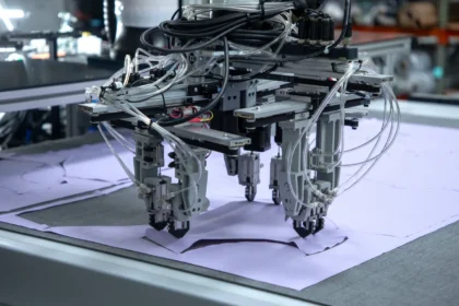 Robots Enter Clothing Manufacturing With a New Method From factories to fashion production Robots already work in car factories, hospitals, and airports. They can assemble complex machines and even assist in surgeries. But clothing production has remained mostly manual. Sewing fabric is still difficult for machines because soft materials shift during handling. Why sewing is hard for robots Fabric is flexible and moves during stitching. Robots struggle to keep two pieces perfectly aligned while working in motion. This makes traditional sewing automation slow and unreliable at scale. Cam Myers, founder of CreateMe, explains that alignment is the main challenge. His company decided to avoid sewing altogether and use a different approach. A new method using adhesive Instead of stitching, CreateMe uses glue to join fabric pieces. A robot applies adhesive, then presses layers together with precision. This process removes the need for needles and thread. The company already uses this system to produce women’s underwear. It plans to start making t shirts soon, with large scale production expected in the near future. Potential impact on global clothing production Today, most garments are made in Asia by low paid workers. Only a small share is produced in Western countries like the United States and the United Kingdom. CreateMe believes automation could shift production closer to home. Some clients want clothing labeled as made in the United States using locally sourced cotton and materials. The company says even moving a small portion of t shirt production back to the United States could reshape the industry. It also believes automation could reduce environmental impact by shortening supply chains. However, this shift could also affect millions of textile workers who rely on garment manufacturing jobs.
