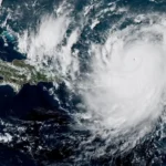 Forecast outlook for the 2026 Atlantic hurricane season Weather experts in the United States expect a less active Atlantic hurricane season in 2026. The National Oceanic and Atmospheric Administration reports a 55 percent chance that the season will stay below normal levels. Forecasters predict between eight and fourteen named storms. Among these, three to six may become hurricanes. One to three could reach major strength. A typical season usually brings around fourteen named storms, seven hurricanes, and three major hurricanes. Why El Niño may reduce storm activity A developing El Niño is one of the main reasons for the expected slowdown in storm activity. El Niño changes wind patterns across the tropical Pacific. It often weakens the usual east to west trade winds. This shift can increase strong upper level winds over the Atlantic. These stronger winds create wind shear. Wind shear disrupts storm formation by tearing developing systems apart before they can strengthen. Because of this, El Niño conditions often limit the number and strength of Atlantic hurricanes. Warm Atlantic waters still support storm formation Sea surface temperatures in the Atlantic are expected to remain higher than average. Warm ocean water usually fuels hurricane development. It gives storms the energy they need to grow stronger. This creates a conflict in the forecast. Warm water supports storm growth, while El Niño conditions work against it. Forecasters believe the El Niño influence will likely be stronger overall, keeping activity lower than usual. What forecasters expect this season Experts expect a quieter season compared with recent years, but they also highlight uncertainty in long range forecasts. Even in a weaker season, strong hurricanes can still form. Weather systems remain difficult to predict with full accuracy months in advance. Officials emphasize that a single powerful storm can cause major damage, even when total storm numbers are low. Why even quiet seasons can still be dangerous Hurricanes can produce severe impacts. These include damaging winds, heavy rainfall, flooding, and storm surge along coastlines. History shows that major hurricanes can strike during quieter seasons. Past storms such as Hurricane Betsy in 1965 and Hurricane Andrew in 1992 caused major destruction despite below average activity overall. What a normal hurricane season looks like A typical Atlantic hurricane season runs from June 1 to November 30. Activity usually peaks in September. On average, the Atlantic produces about fourteen named storms in a season. These range from weaker tropical storms to intense hurricanes. Meteorologists use satellite data, historical records, and computer models to create seasonal forecasts.