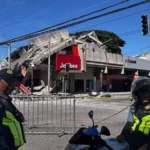 # Major Earthquake in Southern Philippines Kills 32, Triggers Tsunami Alerts A powerful 7.8 magnitude earthquake struck off the coast of Mindanao in the southern Philippines on Monday morning, leaving at least 32 people dead and more than 100 injured. The strong tremor caused widespread destruction, triggered tsunami warnings across several countries, and forced thousands of residents to evacuate. Authorities continue to assess the full impact of the disaster as rescue teams search for missing people and clear damaged areas. ## Tsunami Warnings Issued Across the Region The earthquake occurred at 7:37 AM local time near Mindanao, the Philippines' second largest island. Shortly after the quake, officials issued tsunami alerts for the Philippines, Indonesia, Japan, and Australia. Emergency agencies closely monitored coastal areas. Although authorities later cancelled some warnings, many residents moved to safer locations as a precaution. ## Death Toll Rises as Rescue Efforts Continue Local officials reported that at least 32 people lost their lives due to the earthquake and its aftermath. Many deaths occurred when landslides struck communities in the province of Sarangani, located close to the quake's epicentre. Rescue workers continue searching for nearly two dozen missing individuals. More than 100 people suffered injuries, while emergency teams remain on high alert. ## Sarangani and General Santos Among Worst-Hit Areas Sarangani province recorded the highest number of fatalities, with 17 confirmed deaths. Landslides caused much of the destruction in the area. The earthquake also temporarily disrupted power and communication services, though crews restored most connections later in the day. General Santos City, the closest major city to the epicentre, reported 10 deaths. Authorities also confirmed that several residents remain unaccounted for. The city is widely known for its fishing industry and as the hometown of former world boxing champion and politician Manny Pacquiao. ## Buildings Collapse and Infrastructure Suffers Damage The powerful quake damaged homes, roads, and commercial buildings across several provinces. Videos shared online showed significant structural damage, including the collapse of a Jollibee fast-food restaurant. Authorities also reported damage in South Cotabato and Sultan Kudarat. Engineers are inspecting buildings to determine whether they remain safe for public use. ## Thousands Evacuated for Safety Officials evacuated approximately 10,000 residents from vulnerable areas after the earthquake. Emergency shelters opened to accommodate affected families. Schools in several regions suspended classes following the disaster. The earthquake struck on the first day of the new school year, disrupting activities for thousands of students. In Davao Occidental, footage from a local school showed students gathering in open spaces while the ground shook. Despite the frightening scenes, school officials confirmed that no students suffered injuries. ## Government Mobilizes Disaster Response Philippine President Ferdinand Marcos Jr directed government agencies to coordinate relief and rescue operations. Authorities continue delivering assistance to affected communities and monitoring conditions in high-risk areas. Emergency teams are expected to provide updated casualty figures and damage assessments as rescue operations progress. ## Ongoing Assessment Mindanao is home to approximately 26 million people, making it one of the country's most populated regions. Officials warn that casualty numbers may change as verification efforts continue. Authorities are urging residents to remain cautious, follow safety instructions, and stay informed through official channels while recovery efforts move forward.
