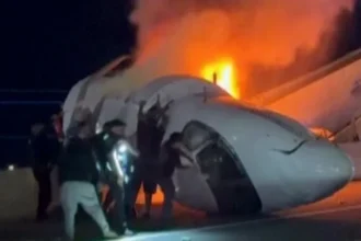 Bystanders Help Rescue Passengers After Fiery Private Jet Crash in Texas Quick action at the crash site A private jet traveling from Los Cabos, Mexico to Austin, Texas crashed onto a motorway near Laredo after reporting serious mechanical trouble. The plane went down close to Laredo airport and burst into flames on impact. Nearly a dozen bystanders and emergency responders rushed in to help. Using tools like a shovel and a sledgehammer, they forced open a door and pulled trapped passengers out before the fire spread further. Casualties and survivors Authorities confirmed that six people were onboard. One person died in the crash, while five others survived and were taken to hospital. Officials said the survivors are in stable condition. The identity of the person who died has not been released. Vehicle struck during impact Investigators said the aircraft also hit a vehicle during the crash on Loop 20 motorway. It is still unclear which part of the plane struck the vehicle. Emergency response and injuries Thick smoke and fire covered the wreckage, according to videos shared online. Five first responders were treated for smoke inhalation after helping at the scene. Road closure and investigation Loop 20 remains closed as investigators continue their work. The probe involves local police, the Federal Bureau of Investigation, and the National Transportation Safety Board. Officials expect the road to stay shut while they examine the cause of the crash and the mechanical issues reported before impact.