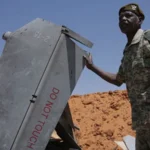 Drone Strike Hits Funeral in El Obeid as Sudan War Intensifies Overview A drone strike hit a funeral gathering in a cemetery in the Sudanese city of El Obeid. At least four people were killed and several others were injured. Two rights groups, Sudan Doctors Network and Emergency Lawyers, reported the incident. They blamed the Rapid Support Forces for the attack. The group has not issued any response. Series of Attacks in One Night Emergency Lawyers said the cemetery strike was part of a wider wave of drone attacks that began on Wednesday evening. At least 23 people were killed across different locations during this period. The group also reported strikes on residential homes, an airport area, and zones near a military base. Civilians were among the dead in these locations. In one residential area, several houses were destroyed and people were trapped under collapsed roofs. A local resident told AFP that destruction was severe. He said survival inside some homes seemed unlikely after the strikes. Civilian Casualties Reported Rights monitors said thirteen civilians were killed when people gathered near damaged homes. Earlier strikes killed five more civilians. In another incident, a truck driver carrying food supplies was killed when his vehicle was hit. The attacks in El Obeid have continued for several days, according to Emergency Lawyers and Sudan Doctors Network. Both groups described repeated targeting of civilian areas. Strategic Importance of El Obeid El Obeid lies in the Kordofan region, an oil rich area divided into North Kordofan, South Kordofan, and West Kordofan. The city sits between territory controlled by the army and areas held by the Rapid Support Forces. Because of this location, it has become a key frontline in Sudan’s ongoing civil war, which has lasted for three years. Control of this region is seen as vital due to its oil resources and transport routes. Humanitarian Crisis Deepens The conflict in Sudan has created one of the worst humanitarian emergencies in the world. More than 11 million people have been displaced from their homes. Around 28 million people are facing severe food shortages. Reliable death counts remain unavailable. Estimates suggest at least 50,000 people have died since the war began.