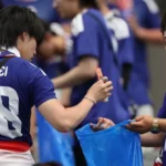 # Japanese World Cup Fans Praised for Stadium Cleanup but Face Criticism at Home ## Japanese Fans Applauded for Stadium Cleanup Japanese football fans have once again gained international attention for cleaning stadiums after World Cup matches. Photos showing supporters collecting trash from the stands quickly spread online and received praise from football fans around the world. Cleaning up public spaces is a long standing tradition in Japan. Many people view it as a sign of respect and responsibility. As a result, Japanese supporters are often recognized for leaving stadiums clean after major sporting events. ## Viral Debate Highlights Household Responsibilities While many people admired the gesture, others in Japan raised a different question. They asked whether the same level of responsibility exists inside the home. A viral social media post sparked the discussion. The image showed a man cleaning a stadium after a football match. Next to it was another image of the same man relaxing on a sofa while his wife handled household chores. The message encouraged Japanese men to contribute more to housework. It suggested that public acts of cleanliness should be matched by equal effort at home. The post quickly gained attention and received more than 60,000 likes on X. Many users joined the conversation. Some argued that helping with daily household tasks is just as important as cleaning public spaces. Others pointed out that many women continue to carry most of the responsibility for childcare and housework. ## Japanese Men Spend Less Time on Housework Recent data supports these concerns. According to figures from the Organisation for Economic Co operation and Development (OECD), Japanese men spend far less time on unpaid household work than women. Data from 2021 shows that women spend more than three hours each day on unpaid work. Men spend only 47 minutes on average. The gap becomes even wider in families with young children. A government survey found that women in dual income households with children under six spend more than seven hours a day on childcare and household duties. Men spend less than two hours. ## Calls for Greater Equality at Home The discussion has renewed calls for a more balanced division of household responsibilities. Many people believe men should play a larger role in childcare, cooking, cleaning, and other daily tasks. Supporters of this view say public behavior should reflect private behavior. They argue that true responsibility includes helping both in the community and at home. As Japanese fans continue to receive praise for their stadium cleanup efforts, the debate has also highlighted a broader issue. Many people now hope the same spirit of teamwork and responsibility can extend beyond the football stadium and into everyday family life.