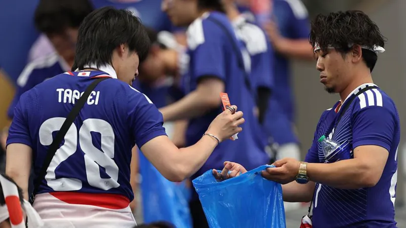 # Japanese World Cup Fans Praised for Stadium Cleanup but Face Criticism at Home ## Japanese Fans Applauded for Stadium Cleanup Japanese football fans have once again gained international attention for cleaning stadiums after World Cup matches. Photos showing supporters collecting trash from the stands quickly spread online and received praise from football fans around the world. Cleaning up public spaces is a long standing tradition in Japan. Many people view it as a sign of respect and responsibility. As a result, Japanese supporters are often recognized for leaving stadiums clean after major sporting events. ## Viral Debate Highlights Household Responsibilities While many people admired the gesture, others in Japan raised a different question. They asked whether the same level of responsibility exists inside the home. A viral social media post sparked the discussion. The image showed a man cleaning a stadium after a football match. Next to it was another image of the same man relaxing on a sofa while his wife handled household chores. The message encouraged Japanese men to contribute more to housework. It suggested that public acts of cleanliness should be matched by equal effort at home. The post quickly gained attention and received more than 60,000 likes on X. Many users joined the conversation. Some argued that helping with daily household tasks is just as important as cleaning public spaces. Others pointed out that many women continue to carry most of the responsibility for childcare and housework. ## Japanese Men Spend Less Time on Housework Recent data supports these concerns. According to figures from the Organisation for Economic Co operation and Development (OECD), Japanese men spend far less time on unpaid household work than women. Data from 2021 shows that women spend more than three hours each day on unpaid work. Men spend only 47 minutes on average. The gap becomes even wider in families with young children. A government survey found that women in dual income households with children under six spend more than seven hours a day on childcare and household duties. Men spend less than two hours. ## Calls for Greater Equality at Home The discussion has renewed calls for a more balanced division of household responsibilities. Many people believe men should play a larger role in childcare, cooking, cleaning, and other daily tasks. Supporters of this view say public behavior should reflect private behavior. They argue that true responsibility includes helping both in the community and at home. As Japanese fans continue to receive praise for their stadium cleanup efforts, the debate has also highlighted a broader issue. Many people now hope the same spirit of teamwork and responsibility can extend beyond the football stadium and into everyday family life.