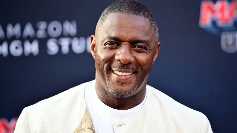 Idris Elba on James Bond Casting and “Woke” Debate: Full Summary Idris Elba speaks on James Bond role and global audience reaction British actor Sir Idris Elba has shared his thoughts on the ongoing debate around the future of James Bond. He said the character should stay true to its original identity and warned against changing it in ways that could divide audiences. Elba also addressed long running speculation linking him to the role of 007, saying he has never been officially in the running, even though he feels flattered by the attention. He explained that James Bond has a specific legacy and tone, and that this should not be altered too much. According to him, the franchise is built on escapism, and changing its core identity to match modern debates could take away from what makes it popular worldwide. Elba comments on diversity and audience expectations Elba pointed out that global audiences react differently to casting choices. He suggested that some viewers may not accept a Black actor in the role of James Bond, especially in certain regions. While expressing this view, he emphasized that Bond is a fictional character and should remain consistent with how it was originally created. He also said that trying to adjust the character to fit every cultural expectation could weaken the story. Instead, he believes the focus should remain on maintaining the traditional style of the franchise. “Man at Arms” role and casting humor Elba is currently appearing in a new project where he plays Man at Arms from Masters of the Universe. He joked about the contrast between his real appearance and the animated character, noting that the role shows how flexible casting can be in fantasy worlds. He highlighted that fictional characters can be reimagined more freely than grounded roles like James Bond. James Bond franchise continues search for new actor The search for the next James Bond is officially underway after years of speculation following Daniel Craig’s departure in No Time To Die. Production insiders confirm that casting auditions are ongoing, although details remain private. The next Bond film will be directed by Denis Villeneuve and written by Steven Knight. Industry reports suggest casting director Nina Gold is leading the selection process. Several well known actors are rumored to be in consideration, including Callum Turner, Henry Cavill, and Aaron Taylor Johnson.