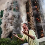 # Hong Kong Files First Criminal Charges in Deadly Wang Fuk Court Fire Case ## Major Legal Action After Deadly Housing Complex Fire Hong Kong authorities have filed the first criminal charges related to the devastating fire at Wang Fuk Court, a tragedy that claimed 168 lives and left thousands without homes. The incident, which occurred in November last year, became the city's deadliest fire disaster in more than seven decades. Prosecutors charged two companies and seven individuals with a total of 25 offences. The allegations include manslaughter, fraud, corruption, money laundering, tax evasion, and attempting to obstruct justice. ## Companies and Executives Face Manslaughter Charges Authorities charged engineering consultancy firm Will Power Architects and construction contractor Prestige Construction and Engineering with manslaughter. Several senior figures also face criminal charges. These include Prestige director Ho Kin-yip, Will Power director Wong Hap-yin, and registered inspector Ng Yeuk. Officials denied bail to all three men during a court hearing on Wednesday. Investigators believe serious safety failures contributed directly to the scale of the disaster. ## Investigation Reveals Critical Safety Failures An independent inquiry found multiple breaches of fire safety regulations throughout the housing complex. According to investigators, workers had disabled fire alarm systems in seven of the eight residential blocks during renovation work. The inquiry also found that contractors had covered windows with highly flammable foam boards. These materials likely accelerated the spread of the fire. Legal representatives leading the inquiry stated that nearly every major fire protection system failed when residents needed them most. Investigators also examined reports that workers frequently discarded lit cigarette butts around the construction site. ## Corruption and Fraud Allegations Expand the Case The case extends beyond fire safety concerns. Hong Kong's anti corruption agency filed additional charges against seven people, including Wong's wife and a close associate. Authorities allege that suspects manipulated the renovation tender process and falsified project supervision records. Investigators also accuse several individuals of laundering money connected to the project. Officials further claim that some suspects attempted to mislead investigators by hiding large amounts of cash and encouraging witnesses to provide false statements. ## More Arrests and Ongoing Investigations Police have arrested 35 people in connection with suspected manslaughter and fraud offences. Separately, anti corruption investigators detained 23 individuals, including contractors, consultants, and members of the building's owners' corporation. Authorities have not confirmed how many of those individuals remain under investigation or have since been released. The court has postponed the case until 2 September to allow investigators additional time to gather evidence and prepare further proceedings. ## Public Response and Media Scrutiny The disaster sparked widespread public concern across Hong Kong. Following the fire, authorities in both Hong Kong and Beijing urged media organizations and commentators to avoid spreading misinformation about the government's response. Days after the tragedy, national security police arrested local columnist Wong Kwok-ngon. Authorities accused him of publishing content intended to create hostility toward the government over its handling of the disaster. As investigations continue, the Wang Fuk Court fire remains one of the most significant public safety cases in Hong Kong's recent history.