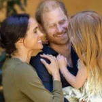 Harry and Meghan Share New Photos as Lilibet Turns Five Lilibet Celebrates Her Fifth Birthday Prince Harry and Meghan Markle marked their daughter Lilibet’s fifth birthday with new family photos. Meghan described her as their “dream girl” while sharing a warm message on social media. The couple continues to share occasional personal moments of their children, giving the public a glimpse into their family life. New Family Photos Shared The first photo shows Harry and Meghan smiling together while holding Lilibet in a close family embrace. The second image captures Lilibet outdoors in a garden. She appears relaxed and curious as she gently touches a flower. These images highlight a calm and private family setting focused on nature and togetherness. Meghan’s Birthday Message on Instagram Meghan posted the photos on Instagram and wrote, “Our dream girl. Happy 5th birthday, Lili.” She has previously shared similar moments of Lilibet, including a playful photo where she referred to her as “Mama’s little helper.” Family Life and Public Updates Lilibet is the couple’s second child and younger sister to Archie by two years. The Sussex family has gradually shared updates about their life outside royal duties. Recently, they celebrated their eighth wedding anniversary by sharing personal photographs from their wedding day. Netflix Projects and Archewell Work The couple’s production company, Archewell, is developing a feature film for Netflix. The project is based on a true story involving British troops during the Afghanistan conflict and adapts the book No Way Out by Major Adam Jowett. Their relationship with Netflix has shifted in recent years, moving from a full contract to a first look agreement, where Netflix gets the first option to review new projects. Recent Public Engagements Earlier this year, Harry and Meghan visited Australia in a private capacity. Their visit focused on Indigenous culture, sport, and community causes, along with a stop at the Australian War Memorial.