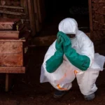 Ebola Response in DR Congo: How Health Workers Are Fighting the Outbreak Safely Introduction Health workers in eastern Democratic Republic of Congo are working under pressure as Ebola cases continue to rise. Their main focus is treating patients quickly while stopping the virus from spreading further in hospitals and communities. Treating Patients in Isolation All suspected and confirmed Ebola patients are kept in isolation units. Medical teams follow strict infection control rules to reduce contact and limit transmission. Every person entering treatment areas must wear full protective gear, including gloves, masks, gowns, and face shields. Protective Equipment and Safety Challenges Health workers rely heavily on personal protective equipment to stay safe. However, supplies are not always enough. Medical groups have raised concerns about shortages, saying many nurses feel at risk because they do not have consistent access to proper gear. Ebola spreads through direct contact with infected body fluids, which makes safety measures critical during treatment and care. The Cube Treatment System One major tool used in care centers is a transparent isolation unit known as the Cube. It allows doctors and nurses to treat patients without direct physical contact. The Cube includes built in glove access points so staff can provide care from outside the sealed unit. It also reduces exposure risk and helps maintain a controlled environment for infectious disease treatment. These units were introduced after the 2014 to 2016 Ebola outbreak and have been used in earlier outbreaks in Congo. Despite their usefulness, the number of available Cubes remains limited compared to the growing number of patients. Additional units are being sent to the most affected areas. Spread of the Outbreak The outbreak began in the eastern region and has since spread to nearby provinces and across borders. Delays in early detection allowed the virus to move from initial hotspots into wider regions. Early Symptoms and Detection Challenges Ebola often begins with general symptoms such as fever, headache, and fatigue. As the illness progresses, patients may develop vomiting, abdominal pain, and diarrhea. These early signs are similar to many other diseases, which makes early diagnosis difficult.