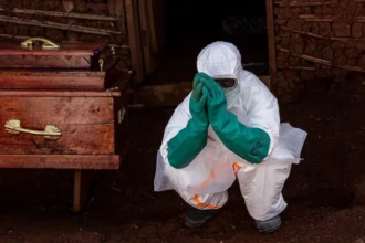 Ebola Response in DR Congo: How Health Workers Are Fighting the Outbreak Safely Introduction Health workers in eastern Democratic Republic of Congo are working under pressure as Ebola cases continue to rise. Their main focus is treating patients quickly while stopping the virus from spreading further in hospitals and communities. Treating Patients in Isolation All suspected and confirmed Ebola patients are kept in isolation units. Medical teams follow strict infection control rules to reduce contact and limit transmission. Every person entering treatment areas must wear full protective gear, including gloves, masks, gowns, and face shields. Protective Equipment and Safety Challenges Health workers rely heavily on personal protective equipment to stay safe. However, supplies are not always enough. Medical groups have raised concerns about shortages, saying many nurses feel at risk because they do not have consistent access to proper gear. Ebola spreads through direct contact with infected body fluids, which makes safety measures critical during treatment and care. The Cube Treatment System One major tool used in care centers is a transparent isolation unit known as the Cube. It allows doctors and nurses to treat patients without direct physical contact. The Cube includes built in glove access points so staff can provide care from outside the sealed unit. It also reduces exposure risk and helps maintain a controlled environment for infectious disease treatment. These units were introduced after the 2014 to 2016 Ebola outbreak and have been used in earlier outbreaks in Congo. Despite their usefulness, the number of available Cubes remains limited compared to the growing number of patients. Additional units are being sent to the most affected areas. Spread of the Outbreak The outbreak began in the eastern region and has since spread to nearby provinces and across borders. Delays in early detection allowed the virus to move from initial hotspots into wider regions. Early Symptoms and Detection Challenges Ebola often begins with general symptoms such as fever, headache, and fatigue. As the illness progresses, patients may develop vomiting, abdominal pain, and diarrhea. These early signs are similar to many other diseases, which makes early diagnosis difficult.