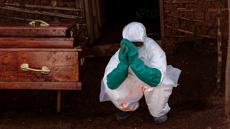 Ebola Response in DR Congo: How Health Workers Are Fighting the Outbreak Safely Introduction Health workers in eastern Democratic Republic of Congo are working under pressure as Ebola cases continue to rise. Their main focus is treating patients quickly while stopping the virus from spreading further in hospitals and communities. Treating Patients in Isolation All suspected and confirmed Ebola patients are kept in isolation units. Medical teams follow strict infection control rules to reduce contact and limit transmission. Every person entering treatment areas must wear full protective gear, including gloves, masks, gowns, and face shields. Protective Equipment and Safety Challenges Health workers rely heavily on personal protective equipment to stay safe. However, supplies are not always enough. Medical groups have raised concerns about shortages, saying many nurses feel at risk because they do not have consistent access to proper gear. Ebola spreads through direct contact with infected body fluids, which makes safety measures critical during treatment and care. The Cube Treatment System One major tool used in care centers is a transparent isolation unit known as the Cube. It allows doctors and nurses to treat patients without direct physical contact. The Cube includes built in glove access points so staff can provide care from outside the sealed unit. It also reduces exposure risk and helps maintain a controlled environment for infectious disease treatment. These units were introduced after the 2014 to 2016 Ebola outbreak and have been used in earlier outbreaks in Congo. Despite their usefulness, the number of available Cubes remains limited compared to the growing number of patients. Additional units are being sent to the most affected areas. Spread of the Outbreak The outbreak began in the eastern region and has since spread to nearby provinces and across borders. Delays in early detection allowed the virus to move from initial hotspots into wider regions. Early Symptoms and Detection Challenges Ebola often begins with general symptoms such as fever, headache, and fatigue. As the illness progresses, patients may develop vomiting, abdominal pain, and diarrhea. These early signs are similar to many other diseases, which makes early diagnosis difficult.