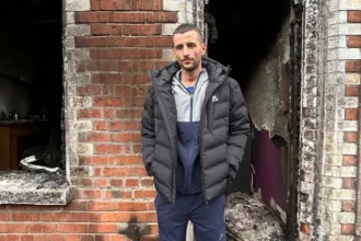 Home Lost in Belfast Fire as Resident Says He Will “Never Get Over” Watching It Burn Residents flee after overnight violence in east Belfast Families in Belfast were forced to leave their homes during a night of unrest that followed a knife attack on Monday. Several houses across the city were damaged after fires broke out during the disorder. Among those affected was a family with a two month old baby, who had to escape as the situation escalated. East Belfast home destroyed in blaze A man from Lendrick Street in east Belfast said he lost the house he had lived in for 13 years after it was set on fire during the chaos. He said the fire began after a nearby car, linked to foreign nationals, was ignited. The flames then spread quickly, leaving little time for firefighters to save the property. By the time emergency crews arrived, the house was already fully burning and could not be saved. “I’ll never get over it,” says homeowner Speaking outside the remains of his home, the man said the experience left him devastated. He described the moment he watched the house burn as something he would carry with him for life. He said the property held many personal and sentimental items that cannot be replaced. Although he expressed anger about the wider violence, he questioned what the destruction had achieved and said it only harmed the local community further. Community impact and ongoing concern The unrest has left several families displaced and facing major losses. While no one from the affected household was injured, the emotional and financial damage is severe. The resident said he was relieved his children were not inside the house at the time of the fire.