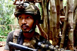 Myanmar Civil War: Forced Conscription Shifts Battlefield Balance Conscription drives civilians into conflict In Myanmar, several young men who never intended to join any armed struggle have ended up in the middle of the civil war. They describe being taken by the military in different situations, including while returning from work, traveling home late at night, or simply lacking proper identification. One former chef says he was detained on his way home and forced into service because he could not show ID. Another man recalls being picked up after a late-night karaoke visit. A third says he was arrested while working in the forestry sector. A fourth claims he was falsely accused after drugs were planted in his belongings, leading to his forced enlistment. Training and harsh conditions The men say they were given basic training for around four months before being sent to the front lines in Karen state. They describe strict routines, little rest, and heavy workloads placed mainly on conscripts rather than regular troops. They also say they were sent into active conflict quickly and had very limited time to adjust or recover. Life in the camps, they explain, was physically exhausting and tightly controlled. Escape and capture by rebel forces During a brief moment of movement away from camp, the group decided to escape. They were later found and detained by members of a local resistance group. Since then, they say they have been treated more fairly and with respect. They describe the experience as being treated like comrades rather than outsiders. They also say returning home is too dangerous. They fear being tracked or arrested again, so plans are being made to move them toward the border with Thailand for safety. Wider impact on the conflict Forced recruitment has become a key factor in changing the balance of the conflict. The military, which took control in 2021 after removing the elected government and detaining its leader Aung San Suu Kyi, has expanded conscription to strengthen its ranks. The civil war has caused widespread destruction, killing thousands and displacing millions across the country. After earlier advances by resistance groups and ethnic alliances, many of those gains have now been pushed back in several regions. The situation continues to shift, with fighting still active across multiple fronts.