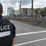 Montreal Police Shooting: Officer, Civilian, and Gunman Killed in Côte des Neiges Attack Incident in a busy neighbourhood A shooting in Montreal on Monday left three people dead, including a police officer, a civilian, and the attacker. One other officer suffered serious injuries but is now in stable condition. The violence took place in Côte des Neiges, a diverse area of the city. Witnesses reported hearing gunfire and seeing a gun pointed from a window. One local resident said he rushed to hide inside a nearby restaurant after hearing the shots and later saw the attacker moving in military style clothing. Police response and suspect details Police said the suspect acted alone and was quickly shot dead at the scene. Authorities have not confirmed a clear motive. Quebec’s public security minister said investigators are still trying to understand why the attack happened. The Royal Canadian Mounted Police also alerted police forces across Canada after reports of a document circulating online that encouraged violence against officers. Officer killed in the line of duty Montreal police identified the officer killed as 34 year old Mohamed Lamine Benredouane. He joined the force in 2021. The department said he will be remembered for his professionalism and dedication, and flags will be lowered in his honour. Police leadership described the situation as deeply traumatic, calling it one of the darkest moments for the force in recent years. Civilian victim identified The civilian killed was identified as Michael Moshe Mizrahi. He was described by community representatives as a respected member of Montreal’s Jewish community. Police have not confirmed that the attack was targeted or motivated by antisemitism. Ongoing investigation Authorities continue to investigate the circumstances surrounding the shooting, including the suspect’s background and possible motives. Officials say more details will be released as the inquiry develops.