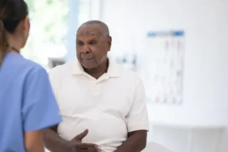 UK Expands Prostate Cancer Screening Trial for Black Men Major step in targeted prostate cancer checks The UK government has expanded a prostate cancer screening trial to include tens of thousands of black men aged 45 to 74. These men will be invited for testing to help improve early detection methods for the disease. Health officials say the aim is to find better ways of identifying prostate cancer earlier, especially in high risk groups. Black men face a much higher risk, with studies showing their lifetime chance of developing prostate cancer is about one in four. Why black men are being prioritised Prostate cancer remains the most common cancer among men in the UK. Around 64,000 men receive a diagnosis each year, and about 12,000 die from the disease. Medical data shows black men face double the risk compared to other groups. Because of this, researchers are focusing on targeted screening to close the gap in outcomes and improve survival rates. What the screening trial includes The government has committed £18 million to support the Transform trial. The study will test whether combining different methods improves accuracy. Participants may receive: PSA blood tests to detect prostate specific antigen levels Genetic testing to identify higher risk variants Faster MRI scans for more detailed imaging Researchers hope this combined approach will reduce missed cases and improve early diagnosis. Debate over routine screening Health experts continue to debate routine screening for all men. The UK National Screening Committee recently advised against regular PSA testing for most men without symptoms. They argue that PSA screening can lead to unnecessary treatment. Some prostate cancers grow slowly and may never cause harm. However, treatment can still lead to serious side effects such as bladder control problems and erectile dysfunction. For now, men are still encouraged to speak with a doctor if they notice symptoms like difficulty urinating. A step toward better future screening Officials believe the expanded trial will help shape a more accurate national screening system in the future. Health leaders say the focus is now on improving precision rather than broad testing. A health spokesperson said the programme is designed to focus on those most at risk and strengthen research to close evidence gaps. Readability and SEO Impro