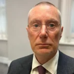 # NHS Trust Chief Executive Shocked by Nottingham Maternity Review Findings ## Trust Accepts Findings of Landmark Maternity Review The chief executive of Nottingham University Hospitals NHS Trust, Anthony May, has expressed shock and sadness following the publication of a major maternity review. The report uncovered serious failings in maternity care and described them as deeply rooted systemic problems. The independent review examined maternity services at the trust and found that hundreds of babies and mothers suffered avoidable harm over several years. It is considered the largest maternity review ever carried out within the NHS. Anthony May said the findings were upsetting, even though investigators had regularly shared updates throughout the review process. He also praised the families who came forward and shared their experiences to help improve maternity care for future patients. ## Hundreds of Cases Showed Avoidable Harm The review involved around 2,500 families and more than 800 current and former staff members. Investigators studied hundreds of maternity cases and identified significant concerns. According to the findings, 520 cases had outcomes that may have been avoided with better care. The report also stated that improved treatment could have changed the outcome for 260 babies. This group included babies who died and others who suffered serious brain injuries linked to poor standards of care. The review concluded that failures in leadership, communication, and clinical practices contributed to many of these outcomes. ## Toxic Workplace Culture Raised Serious Concerns Investigators also highlighted a toxic workplace culture within the maternity unit. Staff reported experiences of bullying and fear, which discouraged some employees from speaking up about safety concerns. The report suggested that a small number of influential leaders contributed to the negative culture. As a result, important concerns were not always addressed quickly or effectively. Review leader Donna Ockenden stressed the importance of creating an open and supportive environment where staff feel confident raising concerns about patient safety. ## Trust Commits to Immediate Improvements Following the publication of the report, the trust board formally accepted all findings and recommendations. Leaders have committed to implementing every essential action outlined in the review. Anthony May described the report as a turning point for the organization. He said the trust remains focused on learning from past mistakes and delivering safer maternity care. He also confirmed his intention to remain in his role for the next two years to oversee the improvement programme. The trust plans to strengthen patient safety measures, improve staff accountability, and rebuild public confidence in its maternity services. ## Families' Voices Driving Change Families affected by the maternity failings played a central role in the review. Many shared difficult personal experiences in the hope that future parents and babies would receive better care. Their contributions helped investigators identify key areas for improvement and highlighted the urgent need for lasting change across maternity services. The trust now faces the challenge of turning recommendations into action and ensuring similar failures do not happen again.