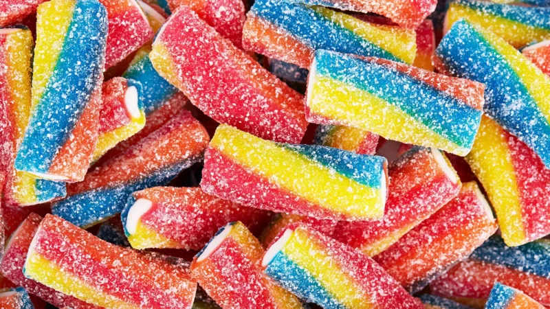 Candy Stores Are Growing in NYC Despite Economic Pressure Why small sweet shops are expanding during tough times New candy shops are appearing across New York City even though many retailers are struggling due to weak consumer confidence and ongoing inflation. While people are cutting back on larger purchases, demand for small treats like candy remains steady. Industry owners say sweets continue to sell because they are affordable and offer quick comfort. Even during financial stress, customers still want small indulgences they can easily justify. A business model that survived the Great Depression One of the strongest examples is Economy Candy on Manhattan’s Lower East Side. It first opened in 1937 during the tail end of the Great Depression and is now known as the city’s oldest candy store. The shop did not start as a candy store. It began as a hat and shoe repair business, with candy sold outside on a small cart to earn extra income. Over time, repairs became less affordable for customers, so the family shifted fully to sweets. That decision helped the business survive, and it is still running today under third generation ownership. Why candy still sells in uncertain times Owner Mitchell Cohen says people still buy candy even when money feels tight. He explains that inflation and uncertainty reduce spending power, but candy remains an easy and low cost purchase. Recent retail data shows overall US sales are still rising, yet consumer sentiment has dropped to record lows. This gap reflects a split between what people feel and what they still spend on. Experts say candy fits into a pattern often called the “lipstick effect.” When budgets shrink, people avoid expensive items but still buy small luxuries that give emotional comfort. New shops are betting on small treats This trend is also attracting new entrepreneurs. Kate Bolger, a former movie producer, is preparing to open The Village Confectionery in Sleepy Hollow, a town near New York City known for its literary history. Bolger believes customers may delay big purchases but will still spend on small treats like candy. She sees it as a simple way for people to enjoy something small without financial strain. A small luxury that stays resilient Even as the wider retail sector faces pressure, candy stores continue to grow in select areas. Their success is linked to low prices, emotional appeal, and steady demand during uncertain economic conditions.