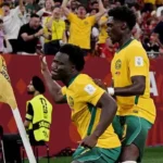 Nestory Irankunda World Cup Journey From Refugee Camp to Australia Star Early Life and Background Nestory Irankunda was born in a refugee camp in Tanzania in 2006. His parents had left Burundi because of war. Later, his family moved to Australia, where he grew up and found football as a passion. He worked his way up through youth football in Australia and joined Adelaide United. His performances quickly stood out because of his speed, skill, and direct attacking style. Rise at Adelaide United At Adelaide United, Irankunda made a strong impact in the A League. He scored 16 goals and added eight assists for the senior team. These numbers helped him build a reputation as one of Australia’s most exciting young players. His form attracted attention from top European clubs. That interest led to a big move to Germany. Move to Bayern Munich In 2024, Irankunda signed for Bayern Munich. He trained with world class players, including Harry Kane. However, he did not get first team minutes. This lack of game time created a problem. He wanted to play regularly to secure a place in Australia’s World Cup squad. To continue his growth, he went on loan to Grasshopper in Switzerland. Even there, he still needed more consistent playing time. Decision to Join Watford In 2025, Irankunda made a bold choice. He left Bayern Munich and joined Watford FC in England. He chose regular football over staying at a top European club. This decision helped him stay in contention for Australia’s national team. It also matched his long term dream of playing in England. International Breakthrough With Australia Irankunda made his Australia debut in a World Cup qualifier against Bangladesh. He scored his first international goals soon after, including a key strike against Palestine. He quickly became one of the youngest scorers in Australia’s football history. His confidence on the field grew with each match. Historic World Cup Moment In a major World Cup match against Turkey, Irankunda scored the opening goal in a 2 0 win. That goal made him the youngest player to score for Australia in a World Cup. The goal marked a turning point in his international career. It also showed why his decision to leave Bayern for more playing time worked out. Playing Style and Reputation Teammates describe him as fast, fearless, and unpredictable. Mohamed Toure called him “Houdini” because of his ability to escape defenders. Some believe he can have a big impact on Australia’s future, similar to top young stars in Europe. His growth now depends on consistency and discipline.