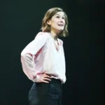 Rosamund Pike Addresses Theatre Etiquette After Audience Member Texting Incident in West End Show Actor pauses curtain call moment to speak about distraction during emotional scene Rosamund Pike interrupted the usual end-of-show atmosphere at London’s Wyndham’s Theatre after noticing an audience member texting during a powerful moment in her West End performance of Inter Alia. The incident happened on Saturday during the closing stages of the play. Pike, known for Gone Girl, Saltburn, Pride & Prejudice, and Die Another Day, returned to the stage alone after the performance. Instead of a standard curtain call announcement, she spoke directly to the audience about theatre behaviour and focus during live acting. Emotional moment prompts onstage message During her brief speech, Pike explained that she and the cast could see audience behaviour and feel its impact during performance. She said it becomes difficult to stay fully immersed when attention is pulled away in key emotional scenes. She avoided directly identifying the person involved but made it clear that texting had been noticed in a crucial moment of the play. Her tone mixed frustration with understanding, as she suggested the message might have been urgent and even joked that the person could be a doctor dealing with an emergency. Call for respect in live theatre spaces Pike stressed that live theatre depends on shared attention between performers and audience. She reminded attendees that the story being told on stage requires focus and emotional engagement from both sides. Her comments were not aggressive, but firm, as she encouraged people to treat theatre as a space that deserves full presence. She also asked the audience not to record her remarks. Audience reaction and response The moment drew gasps from the crowd, followed by applause after she finished speaking. Some audience members later described the atmosphere as uncomfortable at first, then supportive of Pike’s message. One attendee said they initially expected a routine announcement but were surprised by her direct address about the texting incident. About Inter Alia and Pike’s role Inter Alia is a courtroom focused drama written by Suzie Miller, exploring themes of justice, family pressure, and sexual assault within the legal system. Pike plays Jessica Parks, a Crown Court judge balancing intense professional and personal challenges. Earlier in the year, Pike received recognition for her performance, winning a major theatre award for the role.
