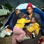 Migrants Face Rising Threats in South Africa as Protest Deadline Nears Violence and fear in Durban settlement A Malawian woman, Esnat Joseph, says armed men came to her home in Durban and ordered her family to leave South Africa. She says the attackers carried machetes and whips and injured her husband during the assault. He was taken to hospital with head and neck wounds. Joseph, who is 36, fled with her one year old triplets and now lives with thousands of other migrants in an open field in KwaZulu Natal. Around 7,000 foreign nationals, mostly from Malawi, have gathered there after leaving nearby informal settlements due to fear and intimidation. Growing pressure on undocumented migrants Tension has increased in parts of South Africa as groups linked to anti migrant demonstrations demand that undocumented foreigners leave the country by 30 June. Protesters, including members of March and March and ActionSA supporters, have staged marches and street gatherings in several areas. Chants of “Mabahambe,” meaning “they must go,” have become common during these demonstrations. While many of the protests have remained peaceful, migrants report threats and door to door intimidation in some communities. Government response and warnings President Cyril Ramaphosa has warned against targeting vulnerable people. He said blaming migrants is not a solution to deeper economic challenges facing the country. Authorities say some undocumented migrants are voluntarily leaving with support from their home countries. Malawi, Ghana, Mozambique, Nigeria and Zimbabwe have arranged transport for citizens who want to return home. Return and uncertainty Thousands have already returned through repatriation programs supported by consulates and donations. However, accounts from returnees suggest fear and rising hostility toward foreigners in some areas. Some migrants, like Benjamin, who recently returned to Nigeria after years in South Africa, say they no longer feel safe living there.