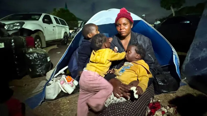 Migrants Face Rising Threats in South Africa as Protest Deadline Nears Violence and fear in Durban settlement A Malawian woman, Esnat Joseph, says armed men came to her home in Durban and ordered her family to leave South Africa. She says the attackers carried machetes and whips and injured her husband during the assault. He was taken to hospital with head and neck wounds. Joseph, who is 36, fled with her one year old triplets and now lives with thousands of other migrants in an open field in KwaZulu Natal. Around 7,000 foreign nationals, mostly from Malawi, have gathered there after leaving nearby informal settlements due to fear and intimidation. Growing pressure on undocumented migrants Tension has increased in parts of South Africa as groups linked to anti migrant demonstrations demand that undocumented foreigners leave the country by 30 June. Protesters, including members of March and March and ActionSA supporters, have staged marches and street gatherings in several areas. Chants of “Mabahambe,” meaning “they must go,” have become common during these demonstrations. While many of the protests have remained peaceful, migrants report threats and door to door intimidation in some communities. Government response and warnings President Cyril Ramaphosa has warned against targeting vulnerable people. He said blaming migrants is not a solution to deeper economic challenges facing the country. Authorities say some undocumented migrants are voluntarily leaving with support from their home countries. Malawi, Ghana, Mozambique, Nigeria and Zimbabwe have arranged transport for citizens who want to return home. Return and uncertainty Thousands have already returned through repatriation programs supported by consulates and donations. However, accounts from returnees suggest fear and rising hostility toward foreigners in some areas. Some migrants, like Benjamin, who recently returned to Nigeria after years in South Africa, say they no longer feel safe living there.