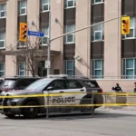 Toronto police officer killed during a raid linked to a consulate shooting investigation in Toronto, with one suspect still at large and police continuing the manhunt.