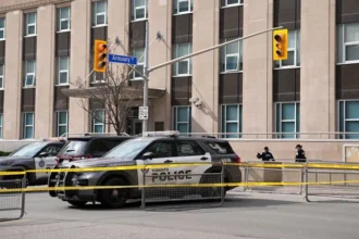 Toronto police officer killed during a raid linked to a consulate shooting investigation in Toronto, with one suspect still at large and police continuing the manhunt.
