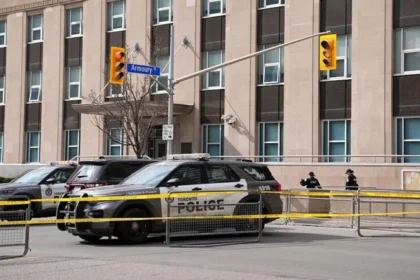 Toronto police officer killed during a raid linked to a consulate shooting investigation in Toronto, with one suspect still at large and police continuing the manhunt.