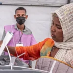 Voting suspended in Ethiopia election amid security concerns Election overview Voting in Ethiopia’s general election has been paused in parts of the Oromia and Amhara regions because of security risks. Election officials confirmed that some polling stations could not operate safely. Despite this, many polling stations across the country remained open, and long queues of voters were seen in several areas. Security disruption affects polling stations Out of more than 50,000 polling stations set up for the election, 143 did not open due to security problems. Conflict in several regions continues to affect voter access and participation. The northern Tigray region was fully excluded from the vote. The area is still recovering from a civil war that ended in 2022, which has left lasting instability. Political context and voter participation This election marks the seventh national vote since the fall of the military government in 1991. It is also taking place under tight media restrictions, limiting international coverage and reporting access. Prime Minister Abiy Ahmed, who has led the country since 2018, cast his vote and highlighted national progress since the end of military rule. He said Ethiopians are capable of shaping their own democratic system without outside guidance. Kenya’s former president Uhuru Kenyatta observed the election on behalf of the African Union and reported that voting appeared to be running smoothly in many locations. Expected outcome and political landscape Abiy Ahmed is widely expected to remain in power with his Prosperity Party. The system selects members for a 547 seat parliament. The party that wins at least 274 seats gains the ability to form the government for the next five years. Abiy came to power after major protests against the Ethiopian People’s Revolutionary Democratic Front, a coalition that had governed since 1991. He later replaced it with the Prosperity Party, shifting the country toward a more centralized political structure.