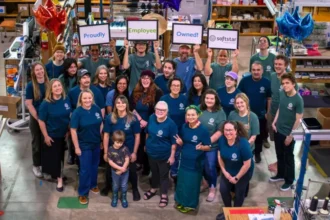 Why I Sold My Business to My Staff: Inside Softstar Shoes’ Employee Ownership Shift Employee ownership at Softstar Shoes Softstar Shoes in Oregon has moved to employee ownership, giving its 30 workers control of the company. The decision followed a full sale by former owner and chief executive Tricia Salcido, who chose to transfer ownership to her team instead of selling to an outside buyer. Salcido is 56 and beginning to plan for retirement. She now works as chief financial officer for the next few years while the staff run day to day operations. Why the business was sold to employees Salcido said she wanted to protect the company’s future and keep production local in the United States. She believed a corporate buyer would likely cut costs and possibly move parts of the work elsewhere. She explained that the business represents years of personal effort and that many small business owners want to protect what they have built, especially when they care about their employees. Staff involvement has increased Since the transition, employees have become more active in decision making. Salcido says workers now send direct suggestions and ideas on how to improve operations and increase efficiency. She noted that this level of engagement was not common before the ownership change. Staff now feel more responsible for both performance and profits. A growing trend in the US Employee ownership is becoming more common across the United States. A recent study suggests around 600 companies per year are now being sold to their workers. Funding for these deals has also grown strongly, rising to about $865 million in 2025 from $500 million in 2024. Benefits of employee ownership Research suggests employee owned firms often perform well. They tend to be more productive, less likely to lay off staff, and may offer higher wages. Workers also share in both the risks and rewards of the business. A wider retirement wave driving change Many business owners in the US are reaching retirement age. A McKinsey report estimates that around six million small and medium sized business owners, mostly from the baby boomer generation, will retire by 2035. Experts warn this could trigger a major wave of ownership changes. Many owners are now exploring employee ownership because their children are not always interested in taking over the business. What experts are seeing Harvard Business School associate professor Ethan Rouen says he frequently meets owners looking to sell. He notes that employee ownership is becoming an attractive option for those who want to protect their workforce and legacy rather than sell to large corporations or private equity firms.