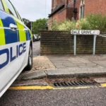A 19 year old woman has died after gunshots were heard at a residential property in Dale Grove, Finchley, north London, shortly after midnight on Monday. Emergency services attended the scene after a call from the London Ambulance Service. When officers arrived, they found the woman with fatal injuries. She was pronounced dead at the location. Her family has been informed and is receiving support from specially trained officers. Emergency response at the scene Police secured the area soon after arriving at the property. The road was cordoned off while emergency teams worked at the scene. Authorities confirmed that formal identification has not yet taken place. A post mortem examination will be carried out to determine further details about the cause of death. Witness accounts from residents Local residents described shock and concern following the incident. One nearby resident, Geraldine Haren, said she was deeply surprised by what had happened. She described the area as calm and family friendly, adding that the community is close knit and usually peaceful. Another resident, Faz Saj, who lives on the same road with his family, said he returned home to find the street blocked. He said the incident felt unusual for the neighbourhood and expressed disbelief at what had taken place. Police investigation underway Detective Chief Inspector Allam Bhangoo is leading the investigation. He said officers are focused on establishing exactly what happened inside the property. He also expressed sympathy for the victim’s family during what he described as an extremely difficult time. Police confirmed that no arrests have been made so far. Officers are continuing to gather evidence and speak to potential witnesses. Authorities expect an increased police presence in the area over the coming days as enquiries continue. Residents have been encouraged to speak with officers if they have any concerns or information. Community reaction The incident has left the local community in shock. Residents described the neighbourhood as usually quiet and safe, making the sudden violence even more distressing. Many people living nearby said they are struggling to understand how such an event could happen in their area. Next steps in the case Investigators will continue examining forensic evidence and witness statements. A post mortem examination will provide further medical details, which may help clarify the sequence of events. Police have stated that updates will be shared once more verified information becomes available.