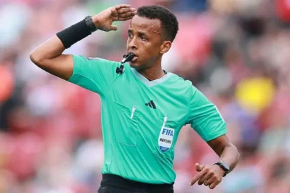 Somali Referee Omar Artan Denied Entry to US Despite Valid Visa Somali referee Omar Abdulkadir Artan has been denied entry into the United States ahead of the World Cup, even though he says he had valid travel documents and a proper visa. He was set to become the first Somali referee to officiate at a World Cup finals. However, he was stopped at Miami International Airport and sent back after an extended immigration process. Long Immigration Interview Before Repatriation Artan said immigration officials held him for an 11 hour interview upon arrival. After that, he was placed in a separate holding area for several hours. Later, he was put on a flight back to Istanbul. No official reason for the decision has been shared by US authorities. FIFA Confirms Removal from Tournament The global football governing body confirmed that Artan will not take part in the tournament. FIFA stated that host country immigration processes are outside its control. It added that officials were informed his entry status would not change. Because of tournament rules, he cannot continue training or officiating even at matches held outside the United States. Training Base Requirements in Miami All referees selected for the World Cup are required to stay at a training base in Miami. This setup is part of preparation and security planning for match officials. Refereeing chief Pierluigi Collina has organized this centralized training system for officials taking part in the tournament. Claims of Valid Documents and Visa Artan insisted that he had all required documents, including a valid visa and supporting travel papers. A Somali sports official also confirmed that he was traveling with proper authorization. Reports say a diplomatic passport had been arranged to support his travel after earlier visa issues. Political Context Around Immigration Rules The case comes amid stricter immigration rules affecting several countries, including Somalia. Earlier remarks from US leadership indicated concerns about Somali immigration, which has added sensitivity to the situation. Artan said he felt disappointed, adding that refereeing at the World Cup was the biggest dream of his career.