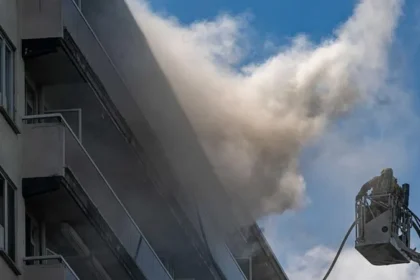 Antwerp Apartment Fire Kills Six, Dozens Injured After Massive Blaze Tragic Fire Breaks Out in Antwerp Residential Building At least six people lost their lives and several others suffered injuries after a devastating fire swept through a 10 storey apartment building in Antwerp, Belgium, on Wednesday morning. Emergency services rushed to the scene after the fire started shortly before 10:00 local time in the Linkeroever district. The blaze produced thick black smoke that quickly spread through the building, forcing residents to escape under dangerous conditions. Firefighters launched a large scale rescue operation as smoke filled multiple floors. Hundreds of Residents Affected Authorities confirmed that more than 200 people live in the apartment complex. Rescue teams evacuated around 80 flats to protect residents from the rapidly spreading smoke. Officials later said that a technical problem on the ground floor likely caused the fire. Investigators continue to examine the exact circumstances surrounding the incident. Emergency crews remained at the site for several hours to secure the building and search every apartment for anyone who might still be trapped. Dramatic Escape Captured on Video Several residents faced terrifying moments while trying to escape. One widely shared video showed a man climbing from his balcony into a neighboring apartment through a window to avoid the heavy smoke. Another resident explained that smoke blocked every possible exit from his apartment. He and his family stayed inside, moved onto their balcony, and waited for firefighters. Rescue crews arrived with a ladder within minutes and safely brought them down. Firefighters Face Difficult Conditions Firefighters worked under extremely challenging conditions because thick smoke reduced visibility throughout the building. The smoke spread much faster than expected, making evacuations more difficult. Rescue teams searched each apartment one by one to ensure that no residents remained inside. Authorities said the fire was nearly under control by Wednesday afternoon, although emergency crews continued inspecting the building for safety. Families Escape, But Pets Could Not Be Saved One resident said his parents in law, including former Antwerp mayor Bob Cools, escaped safely and received medical treatment at a nearby hospital. He also shared that despite every effort by rescuers, the family's pet cat could not be saved. Belgian Leaders Express Condolences Belgian Prime Minister Bart De Wever expressed sympathy for the victims, injured residents, and everyone affected by the tragedy. He described the incident as a heartbreaking event for the Linkeroever community. Lawmakers in the Flemish Parliament also honored the victims by observing a minute of silence before beginning their parliamentary session. Investigation Continues Authorities continue investigating the cause of the fire while engineers assess the building's structural safety. Officials are also providing support to displaced families who cannot yet return to their homes. The tragic incident has raised fresh concerns about fire safety in residential buildings and the importance of emergency evacuation procedures. Local authorities are expected to release additional information as the investigation progresses.