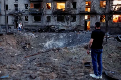 Russia Launches Largest Overnight Missile and Drone Attack on Kyiv, Killing 27 Kyiv Faces One of the Biggest Attacks Since the War Began Russia launched its largest overnight drone and missile assault on Kyiv, leaving at least 27 people dead and 91 others injured. Among the injured were two children. Officials described the attack as the biggest strike on the Ukrainian capital in terms of the number of missiles and drones used. The heavy bombardment damaged homes, public buildings, and emergency facilities across several parts of the city. Authorities ordered evacuations in affected neighborhoods while rescue teams rushed to search for survivors trapped under collapsed buildings. Residential Areas Suffer Heavy Damage One of the worst affected locations was the Darnytskyi district in southeastern Kyiv. Two missiles struck close to a residential area, causing widespread destruction. The first missile created a huge crater beside a kindergarten. The explosion damaged nearby apartment buildings and left balconies twisted and burned. Moments later, a second missile hit the end of a nine story apartment building. A large section collapsed into a pile of concrete and debris. Rescue workers continued searching through the rubble as worried families waited nearby for news of missing relatives. Many vehicles were destroyed, windows shattered, and thick layers of ash covered streets and buildings across the neighborhood. Thousands Take Shelter Underground As air raid sirens sounded across the capital, thousands of residents rushed to underground metro stations for safety. According to city officials, around 52,500 people sheltered in Kyiv's subway system during the attack. The group included about 4,500 children. Authorities said this was one of the highest numbers recorded in recent years. Survivors Share Their Experiences Residents described the terrifying moments during the overnight strikes. Svitlana, who lives next to the damaged apartment block, said she stayed in her hallway while explosions shook the area. She explained that years of living through attacks had changed how she reacted to the sound of missiles. Her family has already suffered devastating losses during the war. A previous strike killed her mother, and her son later died while serving in Ukraine's military. Another resident, Oleksiy, suffered cuts after flying glass struck him. He had stepped outside after hearing the first explosion when the second missile landed nearby. Despite his injuries, he survived the attack. Russia and Ukraine Exchange Accusations Russian officials said the overnight strikes targeted military production facilities. Moscow claimed the operation responded to recent attacks on Russian civilian infrastructure and stated that pressure on Ukraine would continue. Ukraine strongly rejected those claims. Officials argued that the missiles struck residential neighborhoods instead of military sites. They also said the attack should not be compared with Ukraine's actions because the country is defending itself against the invasion. Rescue Operations Continue Emergency crews continued clearing debris throughout the day as they searched for anyone still trapped beneath collapsed buildings. The latest assault highlights the continuing danger facing civilians in Kyiv. As rescue operations move forward, officials fear the number of casualties could rise if more victims are found under the rubble.