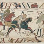 Bayeux Tapestry Returns to UK After 900 Years Under Heavy Security The famous Bayeux Tapestry has arrived in the United Kingdom for the first time in almost 900 years. The historic 11th century artwork reached the British Museum under strict police protection after being transported from northern France. The 70 metre long embroidered masterpiece shows 58 detailed scenes from the events before the Battle of Hastings and the Norman Conquest of England in 1066. The battle changed the future of England and remains one of the most important moments in British history. Historic Arrival at the British Museum The valuable artwork arrived at 02:50 BST in a specially protected transport vehicle. A large secure crate containing the tapestry was carefully removed from the lorry at the British Museum loading area. Museum officials, including British Museum director Nick Cullinan and the French ambassador to the UK, attended the historic arrival. Cullinan described the moment as extraordinary and said the museum was excited to share the rare artwork with visitors from around the world. The exhibition team also expressed their emotions during the arrival. Millie Horton Insch, the project curator for the exhibition, said seeing such an important historical object arrive was a deeply meaningful experience. A Masterpiece From the 11th Century The Bayeux Tapestry is not a traditional painting. It is a detailed embroidery that tells the story of William the Conqueror’s journey and the events that led to the Norman takeover of England. Historians believe the artwork was created shortly after the Battle of Hastings. It provides a unique view of medieval life, warfare, ships, soldiers, and political events from nearly 1,000 years ago. The British Museum will place the tapestry on public display in September, allowing visitors to experience one of the world’s most important historical treasures. France and UK Celebrate Cultural Friendship French President Emmanuel Macron described the loan as a symbol of friendship between France and the United Kingdom. He called it a sign of trust and cooperation between the two countries. To celebrate the occasion, the British Museum displayed a projection of the tapestry on the White Cliffs of Dover with the French message “Merci” as a gesture of appreciation. Concerns Over Moving the Historic Artwork Although many people welcomed the exhibition, some concerns were raised in France about transporting such a fragile object. A French petition argued that moving the tapestry could put the historic item at risk. Some experts and artists also questioned whether the artwork should travel due to its age and delicate condition. Despite these concerns, the Bayeux Tapestry has now safely reached the UK, where it will become one of the most significant historical exhibitions of the year.