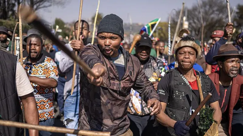 South Africa Deports More Than 53,000 Foreign Nationals in Migration Crackdown South Africa has deported and repatriated more than 53,000 foreign nationals as the government continues a major campaign against undocumented migration. The action comes after weeks of protests calling for stronger border controls and the removal of people living in the country without legal documents. The government said most of those affected came from Malawi, Zimbabwe, and Mozambique. Officials expect the number to increase as immigration operations continue across the country. Anti Immigration Protests Increase Pressure on Government The crackdown follows growing anger among some South African communities over undocumented migration. Protesters have accused foreign nationals of worsening unemployment, increasing crime, and putting pressure on public services. Several demonstrations have taken place across the country, with activists demanding stricter immigration policies. Some groups have also called for regular protests until the government takes stronger action. However, international organisations have warned against blaming migrants for South Africa’s economic problems. The United Nations has urged authorities and citizens to avoid using migrants as scapegoats for challenges such as poverty and unemployment. Government Confirms Deportation Numbers South Africa’s Justice and Constitutional Development Minister Mmamoloko Kubayi said authorities had processed 53,499 foreign nationals for deportation and repatriation. She explained that the majority were Malawian citizens, followed by Zimbabweans and Mozambicans. According to the minister, the operation has also helped police identify people wanted for alleged criminal offences. Kubayi said the government wants to create an organised migration system that respects both national laws and human rights. She added that immigration officials will continue enforcing the country’s rules but warned protesters against carrying out illegal searches of homes and businesses. Foreign Nationals Leave Amid Rising Tensions The protests have created fear among some migrant communities. Reports suggest that many foreign nationals have left South Africa because of threats, intimidation, and concerns about possible violence. Countries including Ghana, Nigeria, Uganda, and Kenya have helped some citizens return home through organised flights. South African President Cyril Ramaphosa has recognised public concerns about immigration but has strongly condemned attacks against migrants. He urged citizens to allow law enforcement agencies to handle immigration issues instead of taking matters into their own hands. South Africa Faces Migration Challenges South Africa remains one of Africa’s strongest economies and continues to attract migrants searching for jobs and better living conditions. Many foreign nationals enter the country legally, while others cross borders without proper documents. The government says it will continue managing migration while balancing public concerns with the rights and dignity of all people living in South Africa.