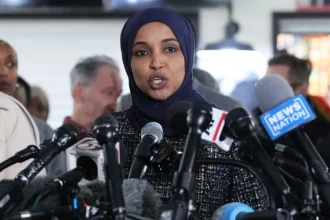 Homeland Security officer walks along a Washington, D.C., street during the October 12, 2026, investigation at Representative Ilhan Omar's residence.